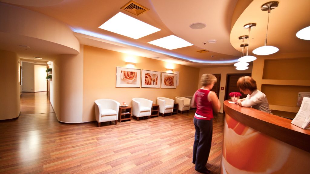 woman checks in a arced reception desk in lobby